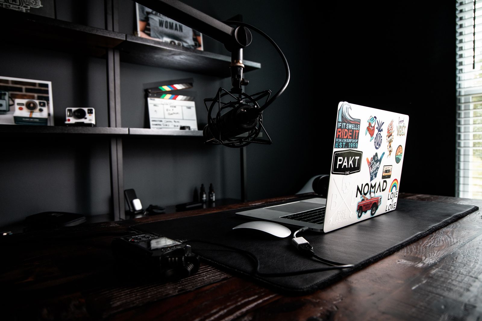 Mesa de estúdio com notebook, gravador portátil e braço de microfone articulado