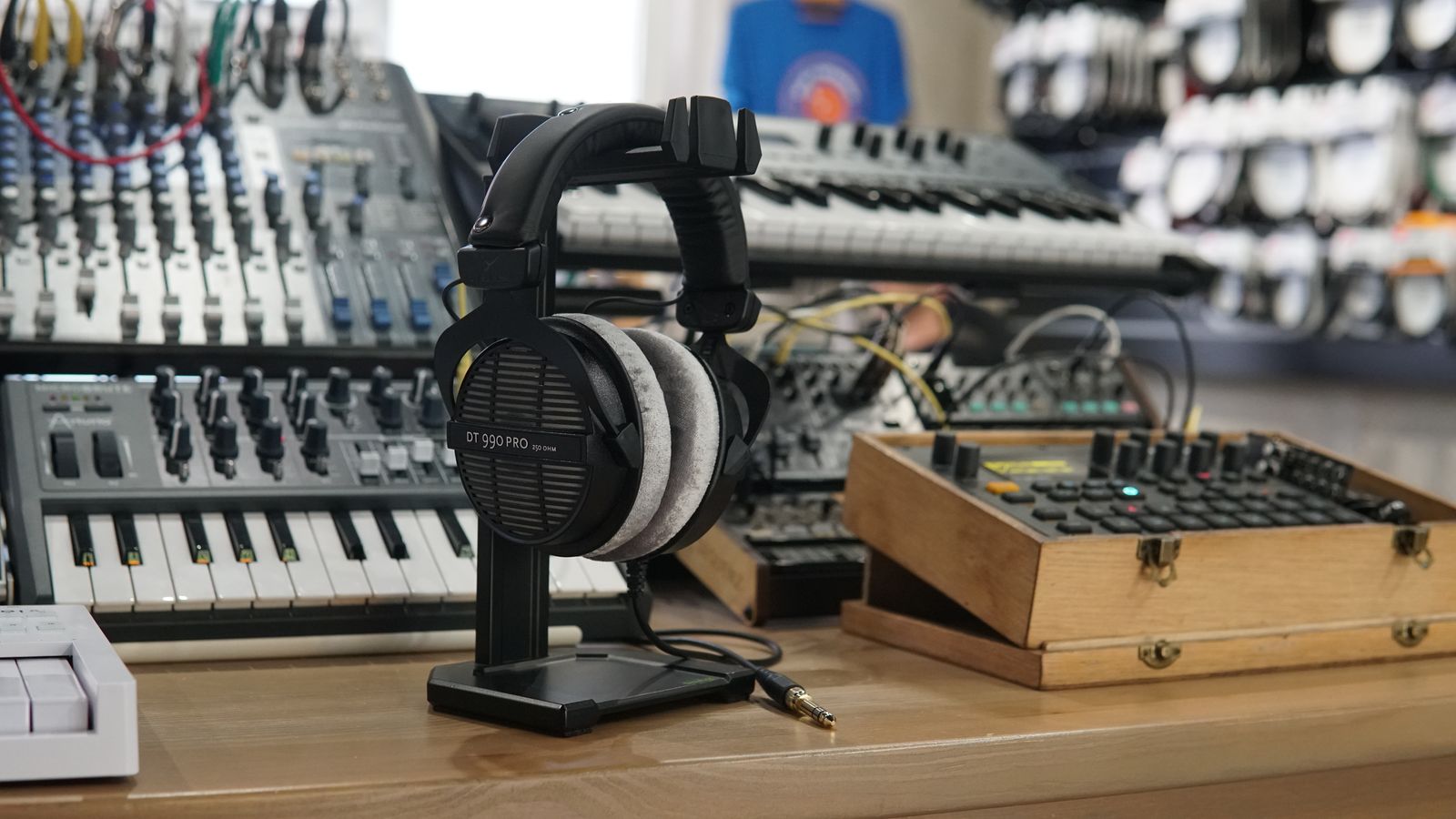 Microfone com pop filter montado em braço articulado ao lado de notebook